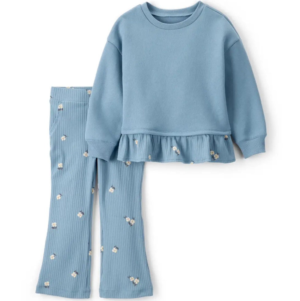 Blue outfit with ruffled top and ribbed pants on a white background