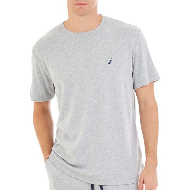 Person wearing a gray t-shirt with a small logo on a white background