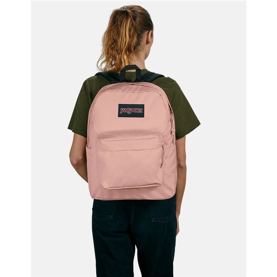 Person wearing a pink Jansport backpack with a brand logo on a white background