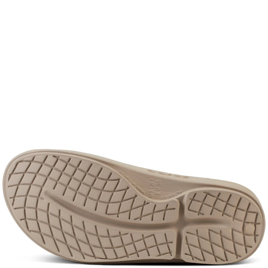 Close-up of a beige shoe sole with tread pattern on a white background