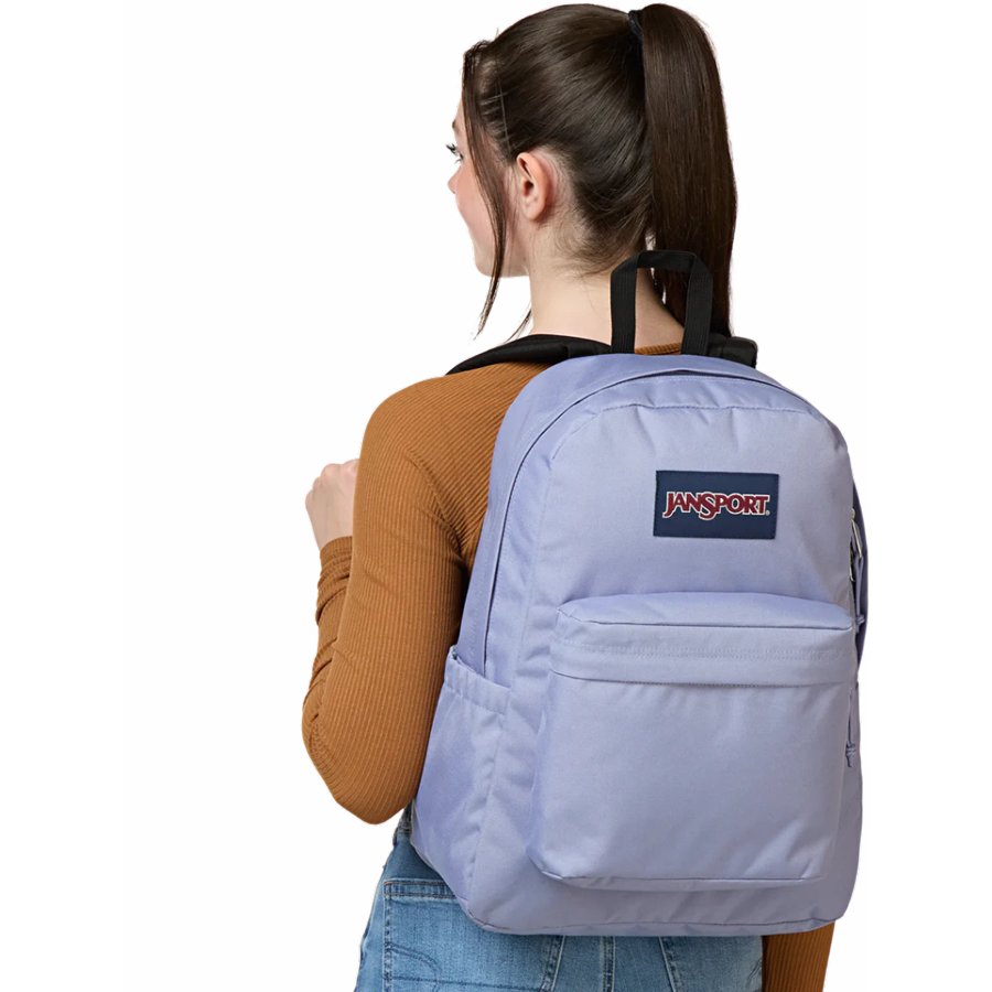 Person wearing a lavender backpack with JanSport logo on a white background