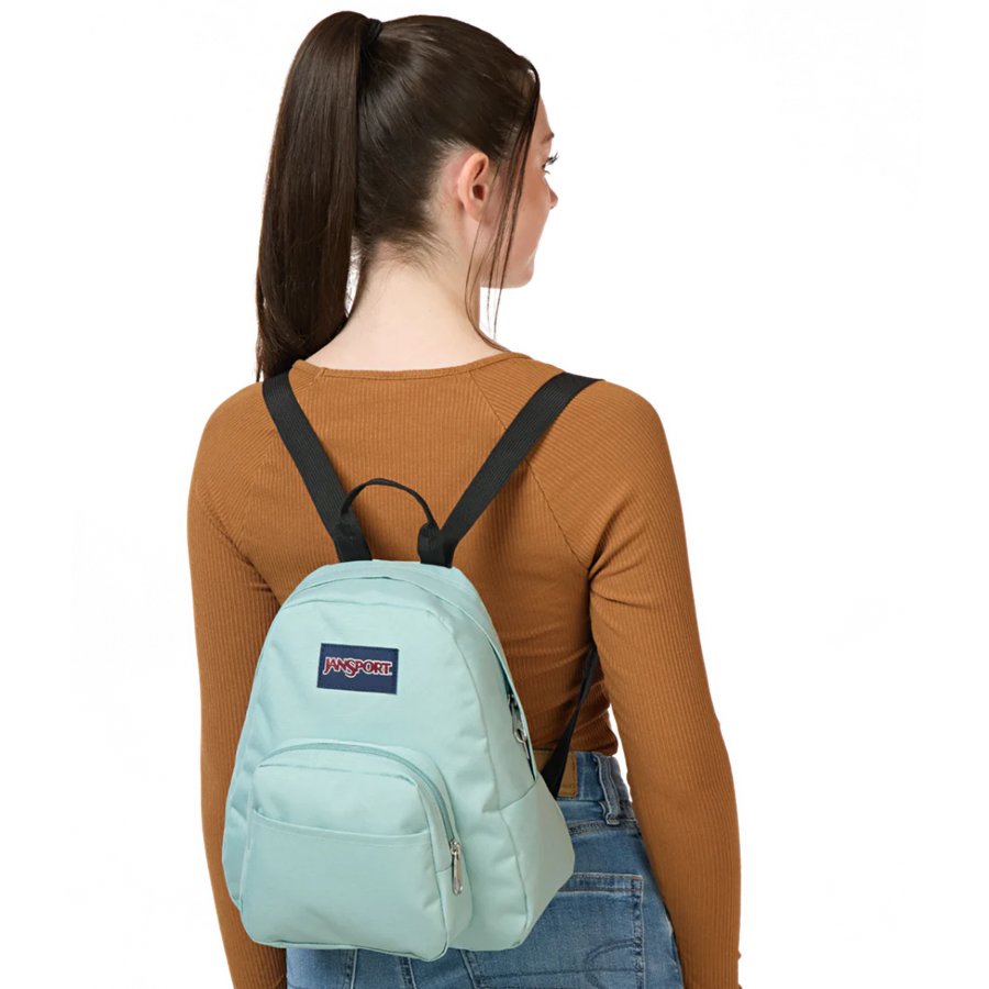 Person wearing a light blue Jansport backpack with a visible brand logo on a white background