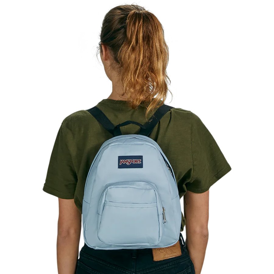 Person wearing a light blue Jansport backpack with a visible brand logo on a white background