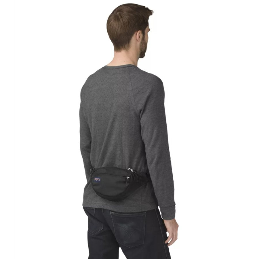 Person wearing a black Jansport waist bag on a white background