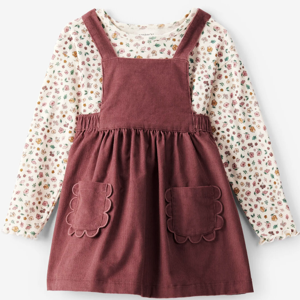 Children's outfit with a floral shirt and maroon pinafore dress on a white background