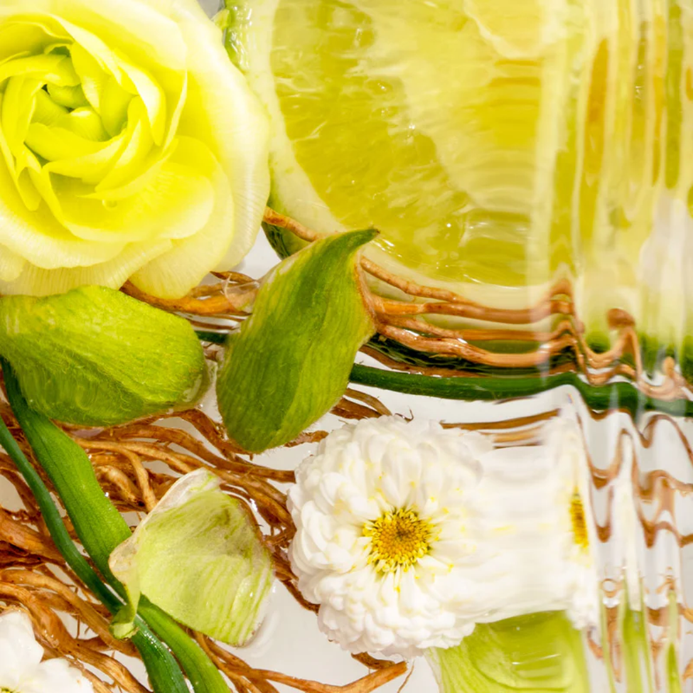 Close-up of a decorative item with green roses and a white flower on a textured surface.