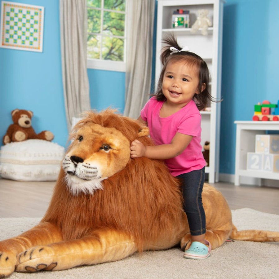 Child playing with a large stuffed lion toy in a colorful room.