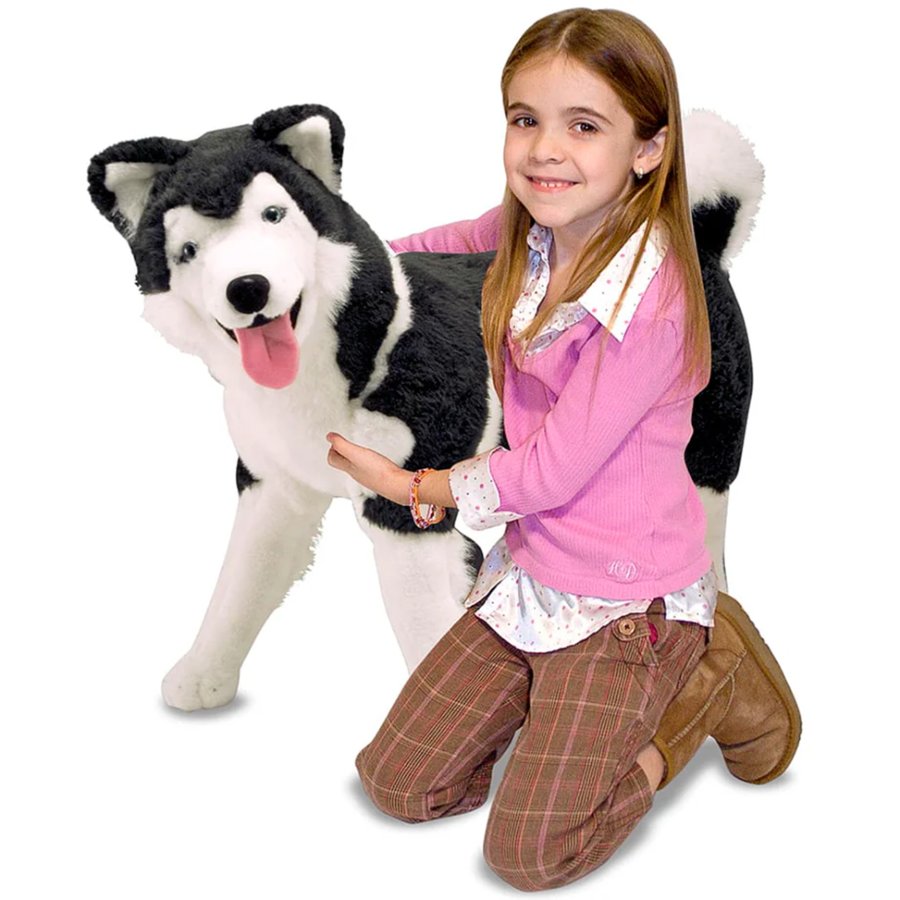 Girl with a large plush dog toy on a white background