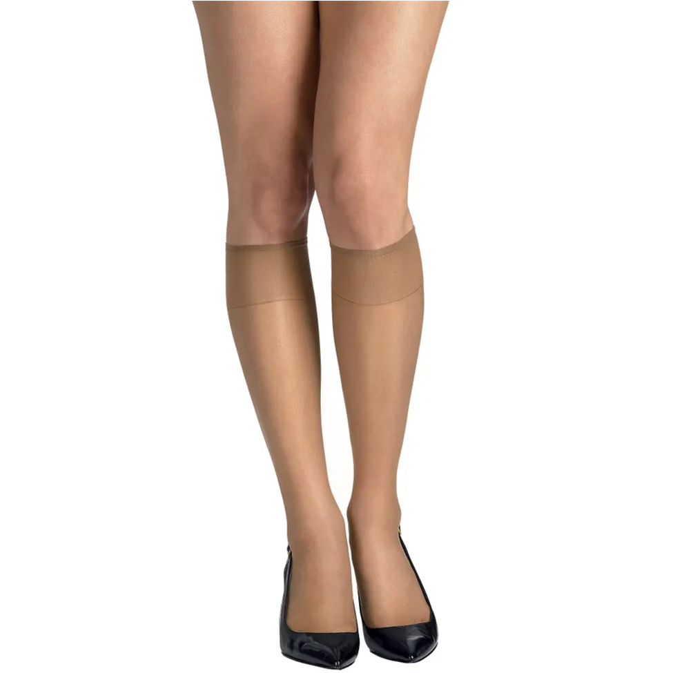 Beige tights worn with black shoes on a white background