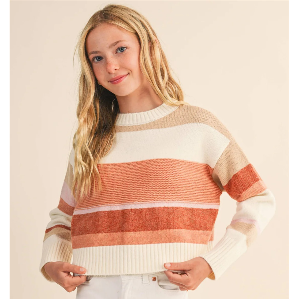 Woman wearing a striped sweater with a plain background