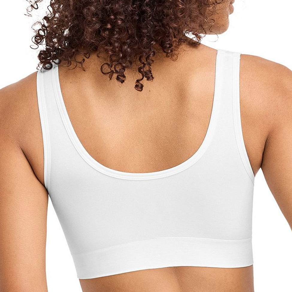 White sports bra worn by a person with curly hair on a white background