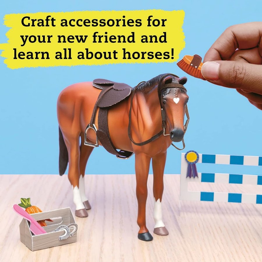 Toy horse with accessories and a hand holding a brush against a blue background