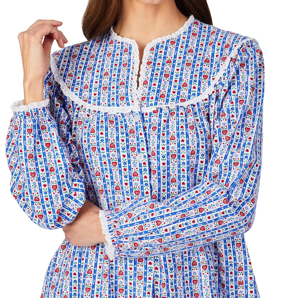 Woman wearing a blue patterned dress with white lace trim on a white background