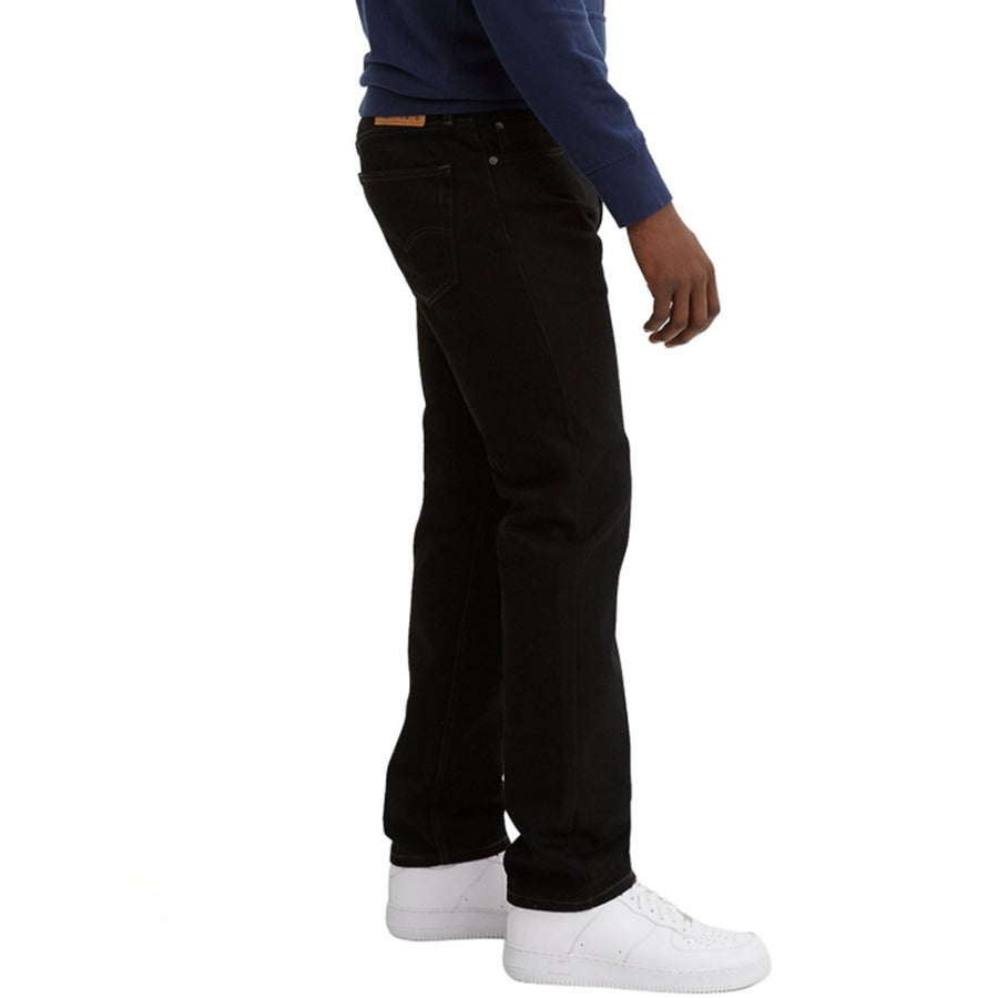 Person wearing black jeans and white sneakers on a white background