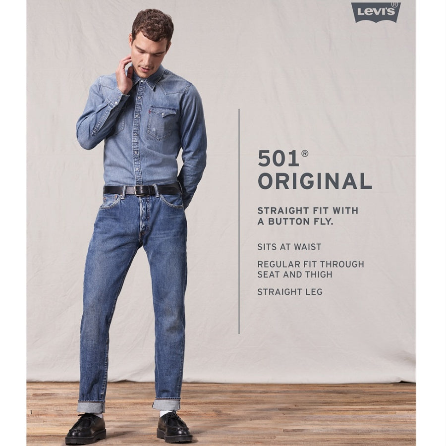 Man wearing a Levi's 501 Original jeans and shirt against a plain background