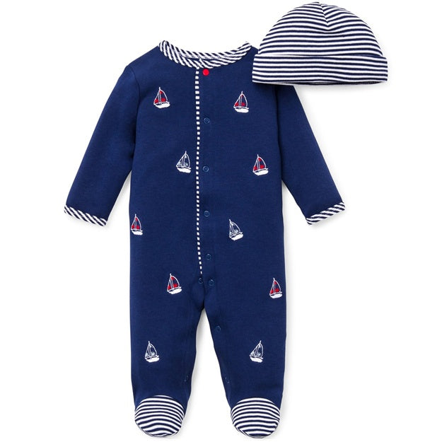 Navy baby onesie with sailboat pattern and matching hat on a white background