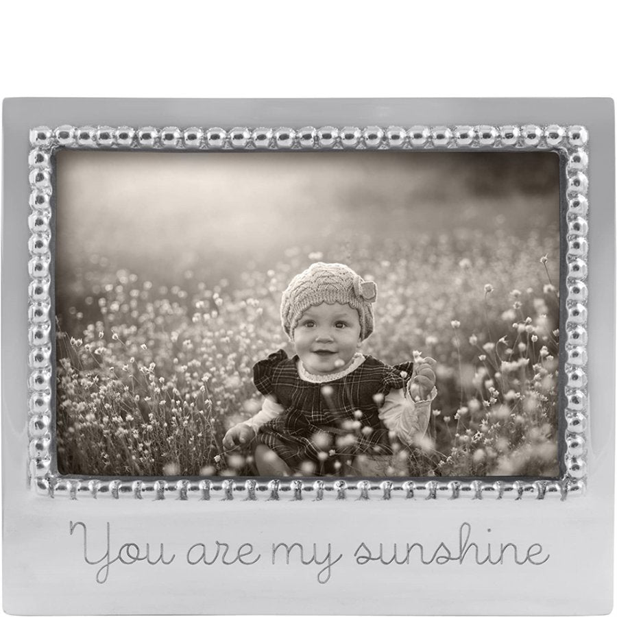 Silver photo frame with 'You are my sunshine' text, containing a black and white photo of a child in a field.