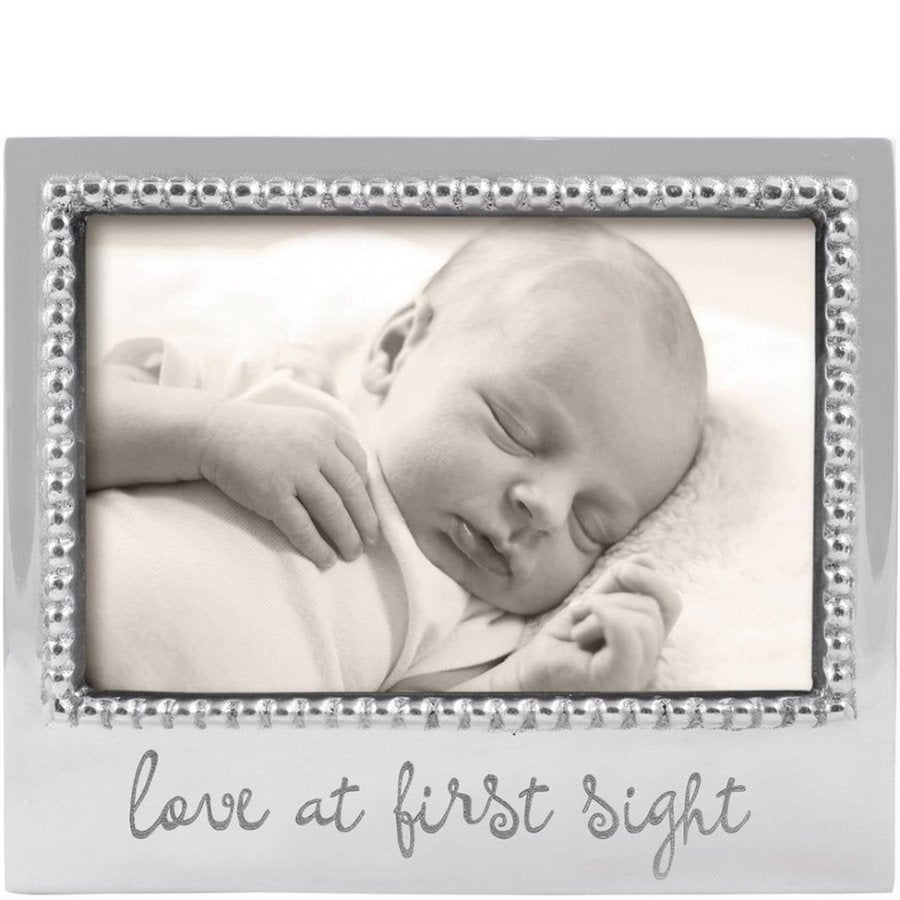 Baby sleeping in a decorative frame with 'Love at First Sight' text