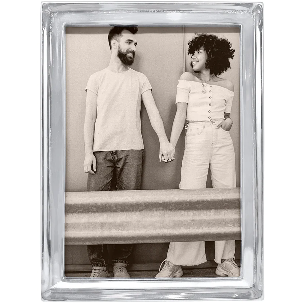 Silver photo frame with a black and white photo of two people holding hands.