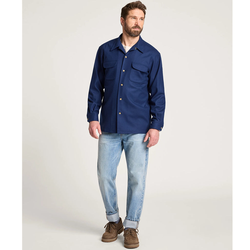 Man wearing a blue jacket and jeans on a white background