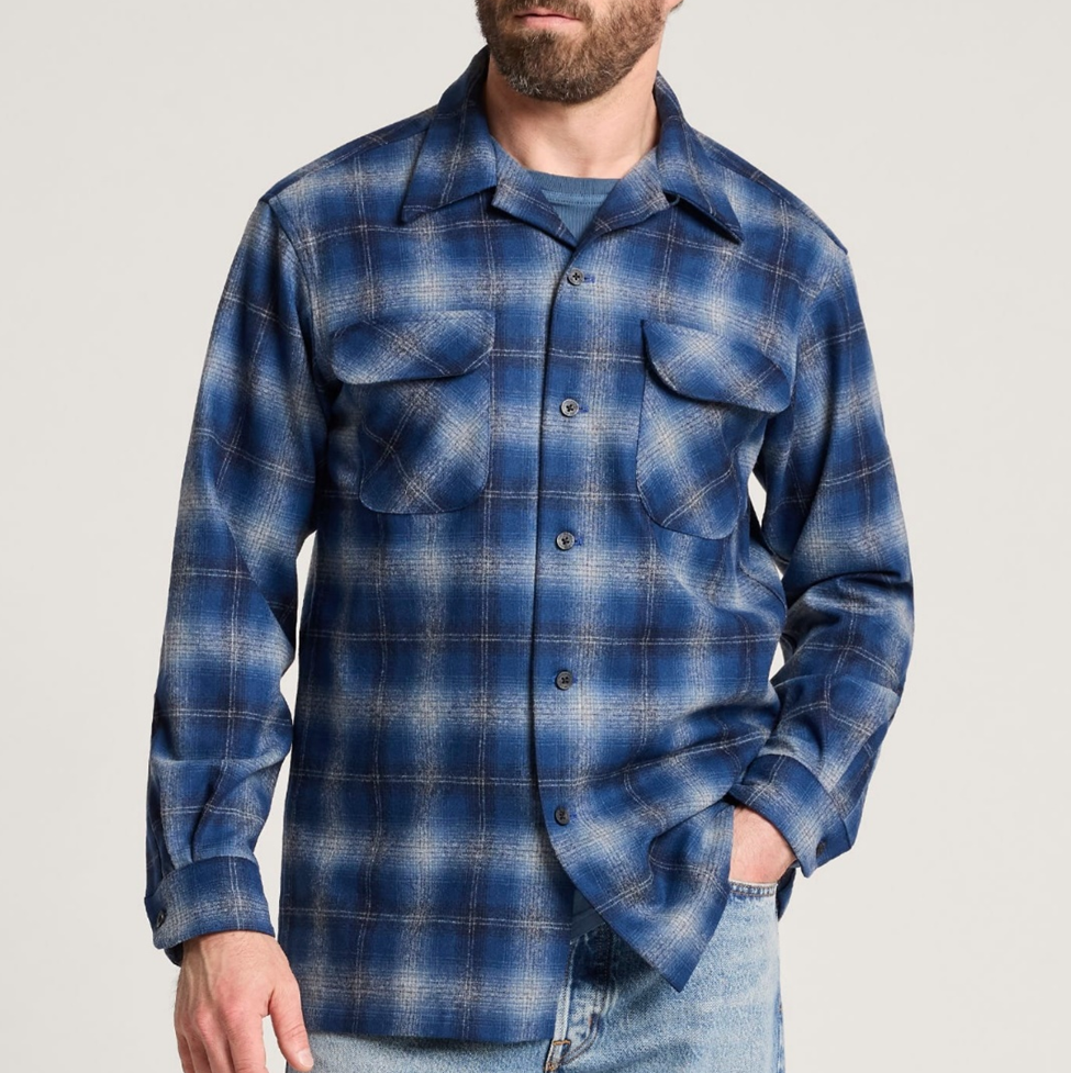 Man wearing a blue plaid shirt against a plain background