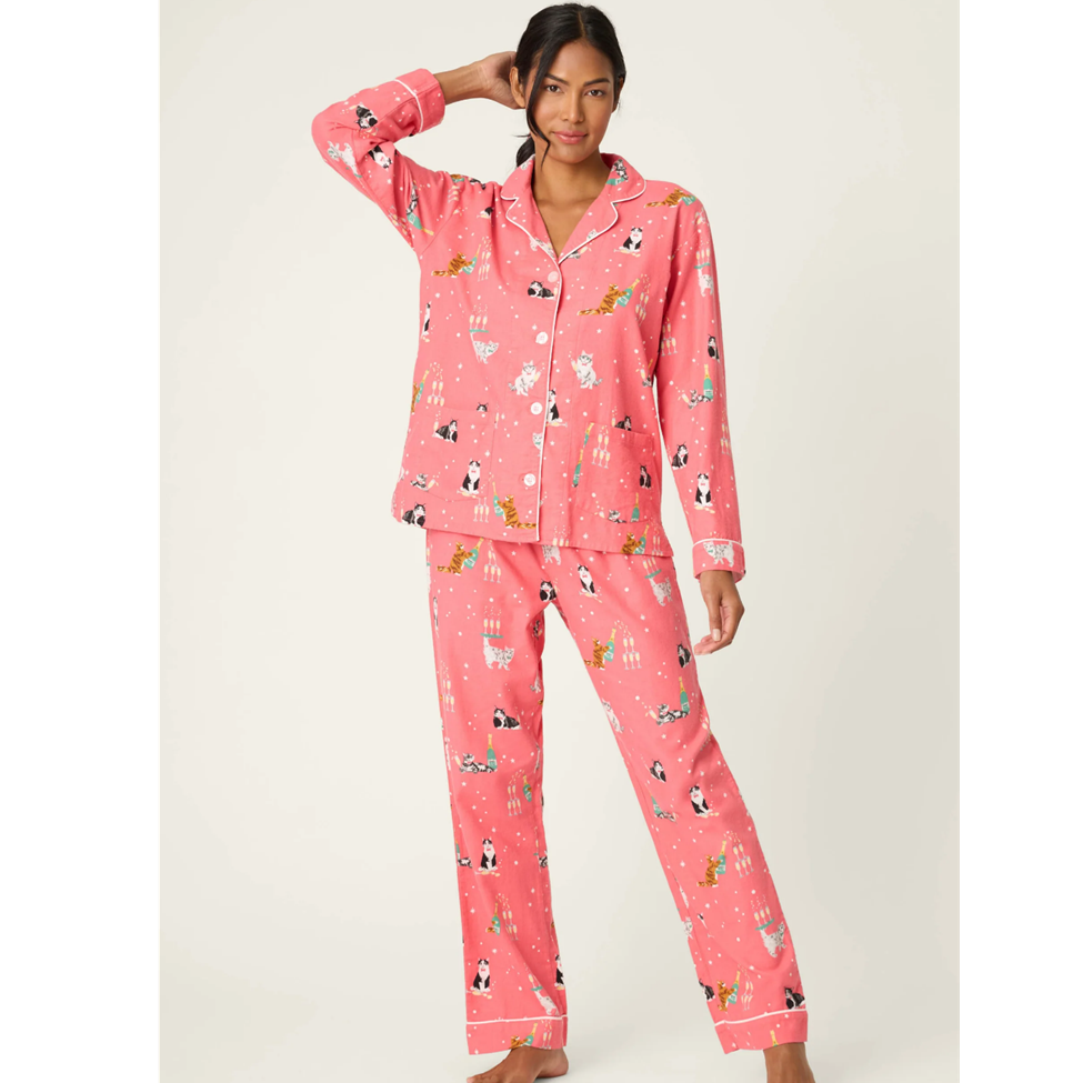 Woman wearing pink pajamas with animal print on a white background
