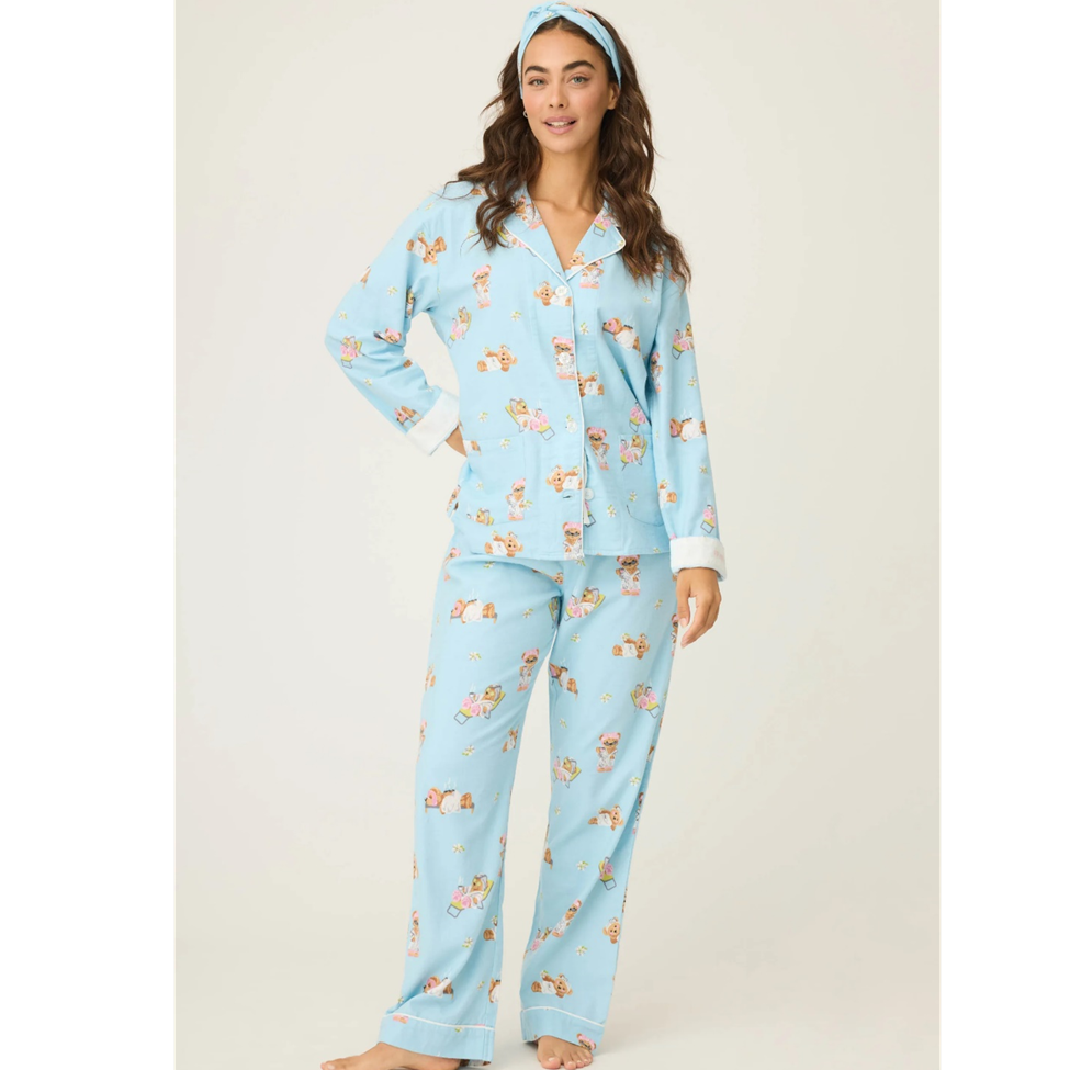 Woman wearing a light blue pajama set with a floral pattern on a white background
