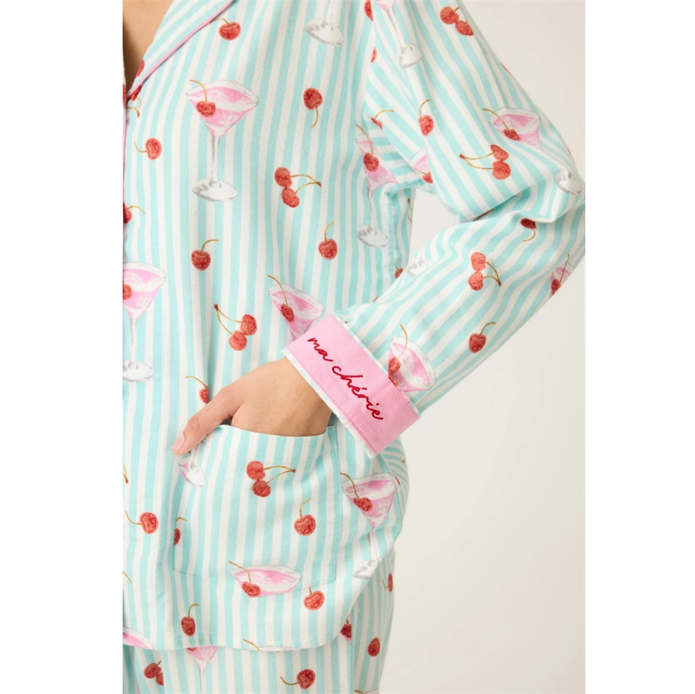 Teal and white striped pajama set with pink cherries and cocktail design, worn by a person.