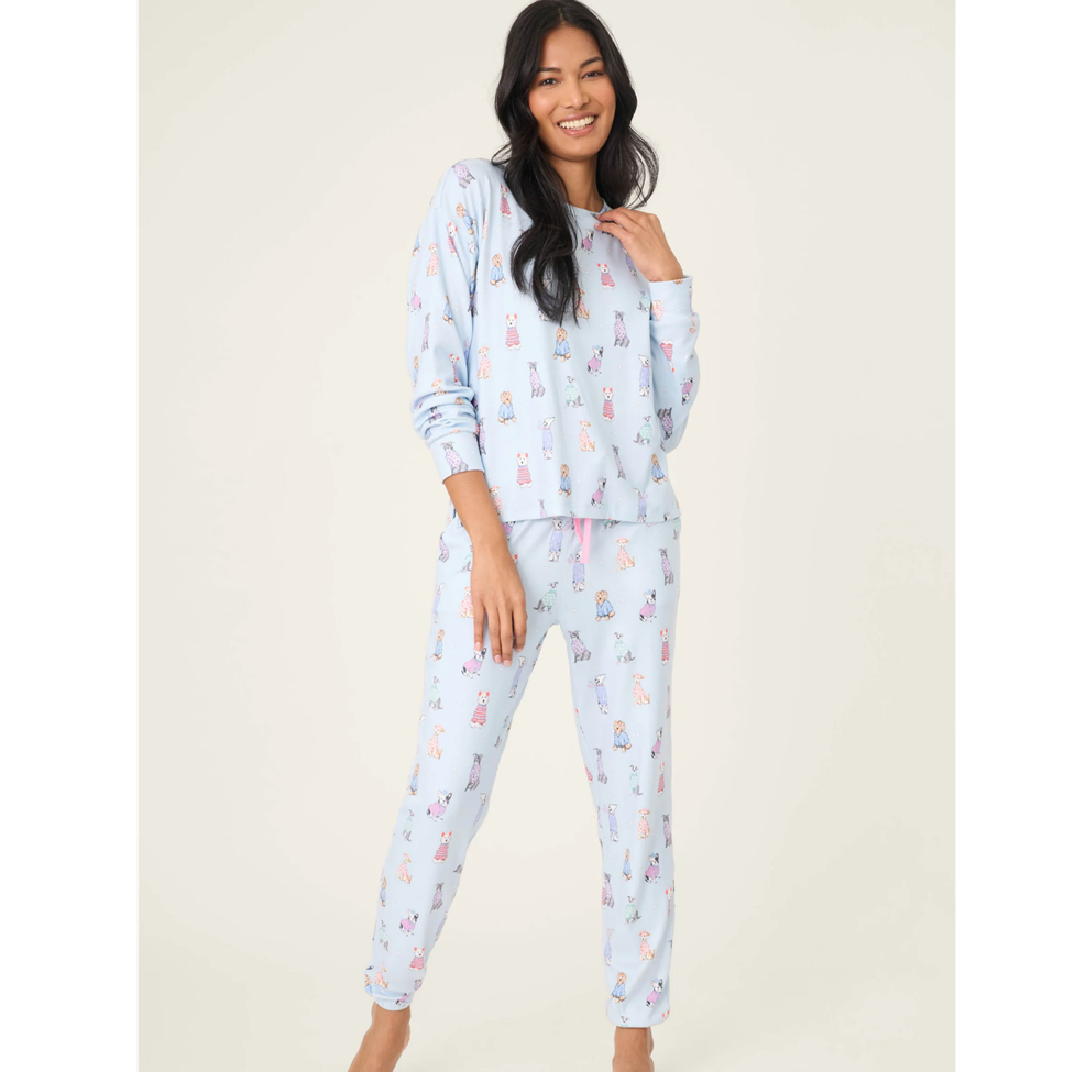 Woman wearing a light blue pajama set with animal print on a white background