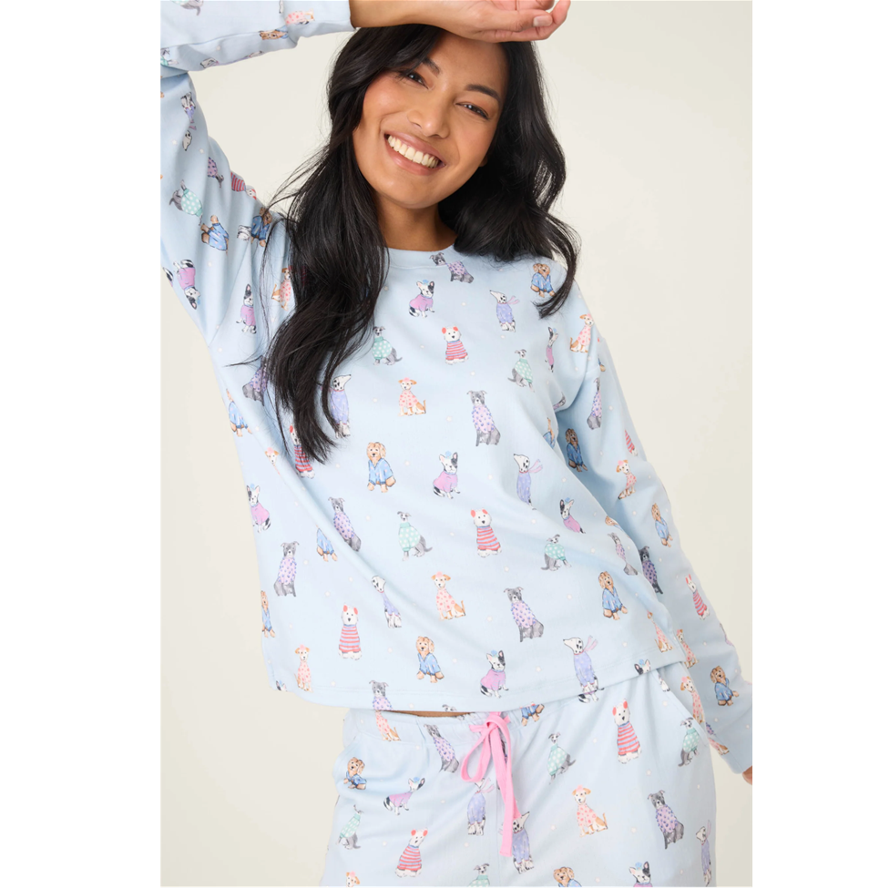 Woman wearing a light blue pajama set with animal prints on a white background