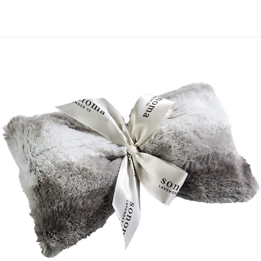 Gray fluffy blanket with a white ribbon and branding on a white background