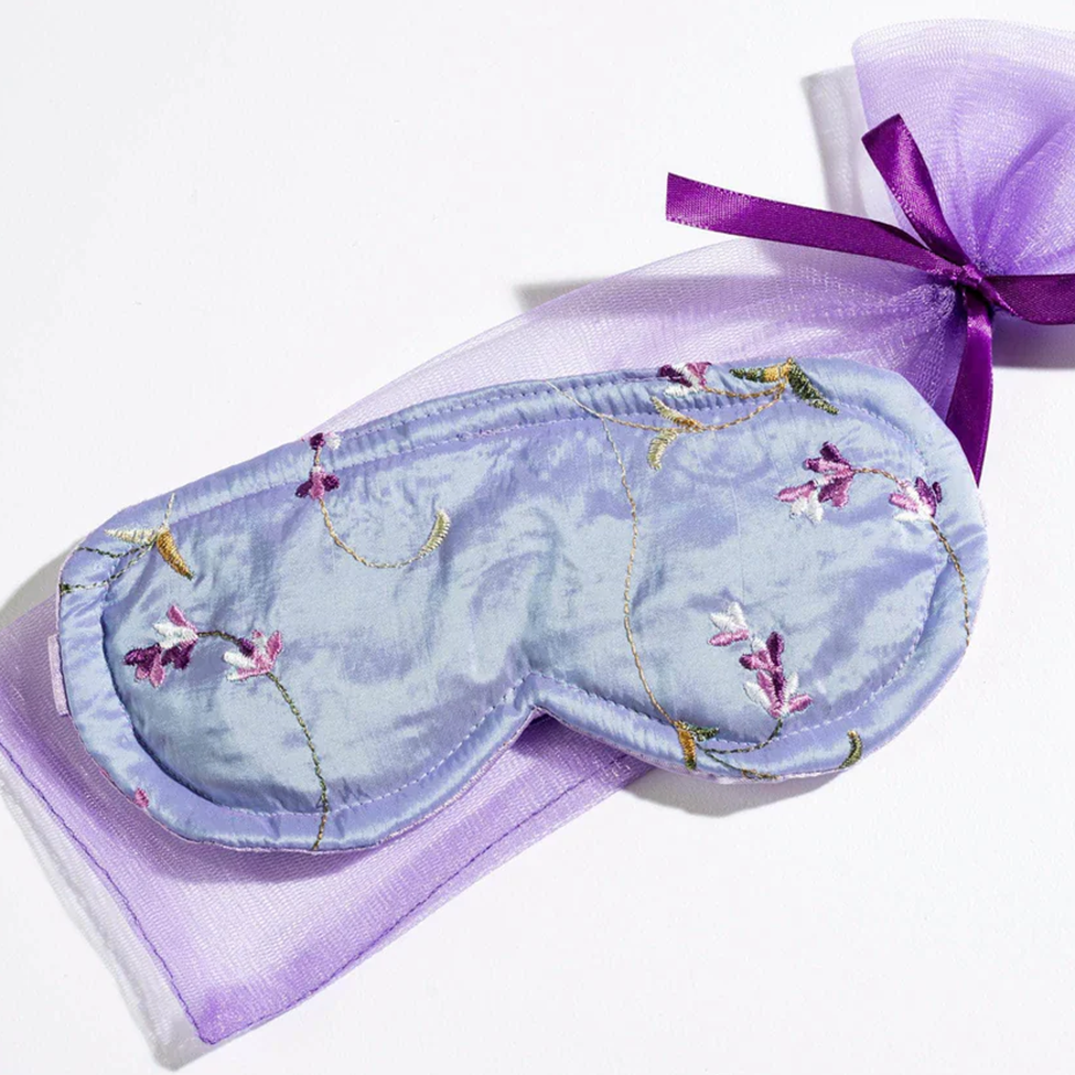 Embroidered eye mask with floral patterns on a white background