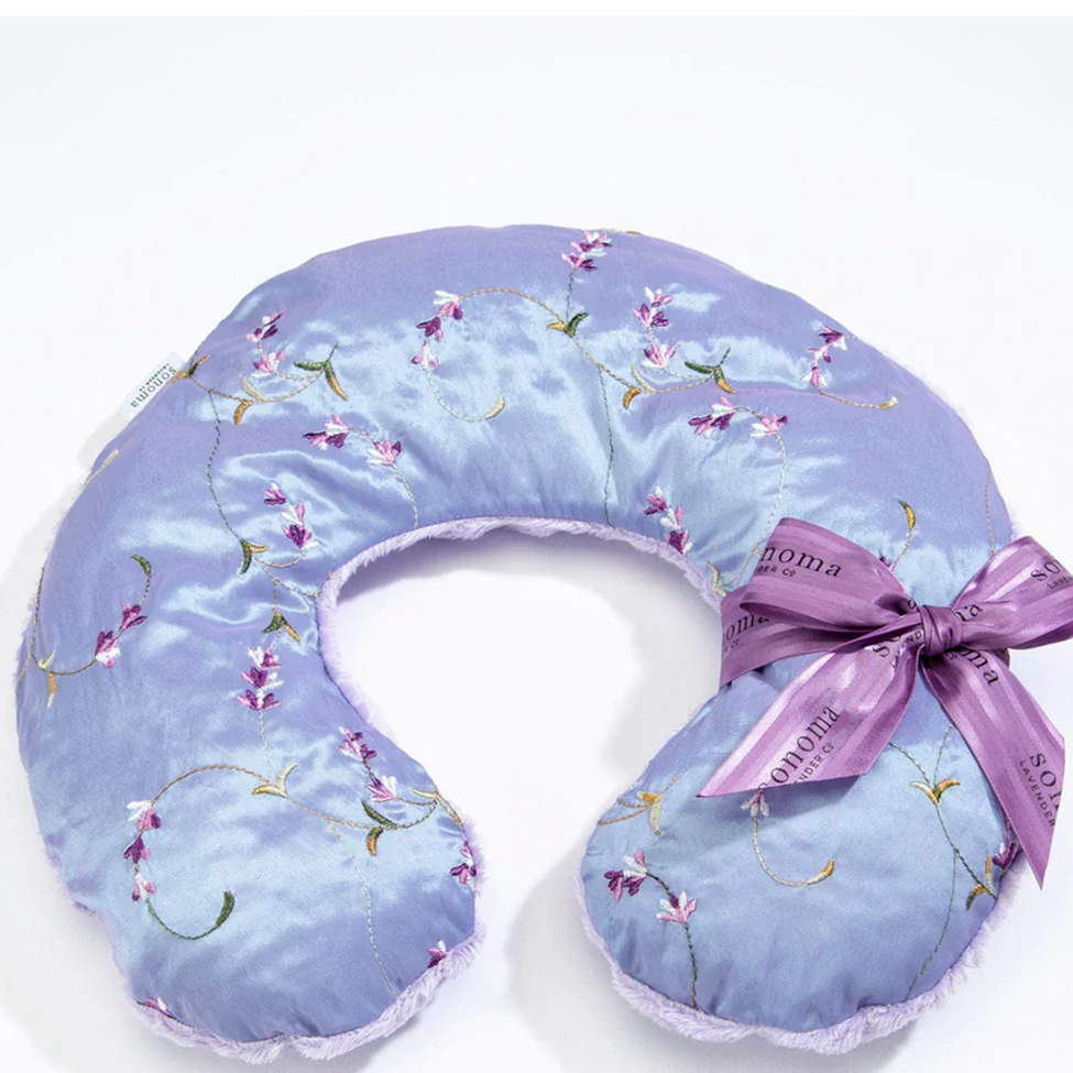 Floral-patterned neck pillow with a ribbon on a white background