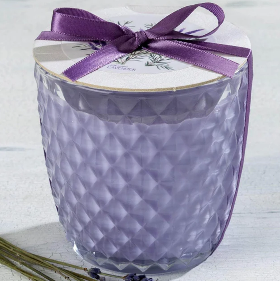 Decorative candle with a purple ribbon on a white background