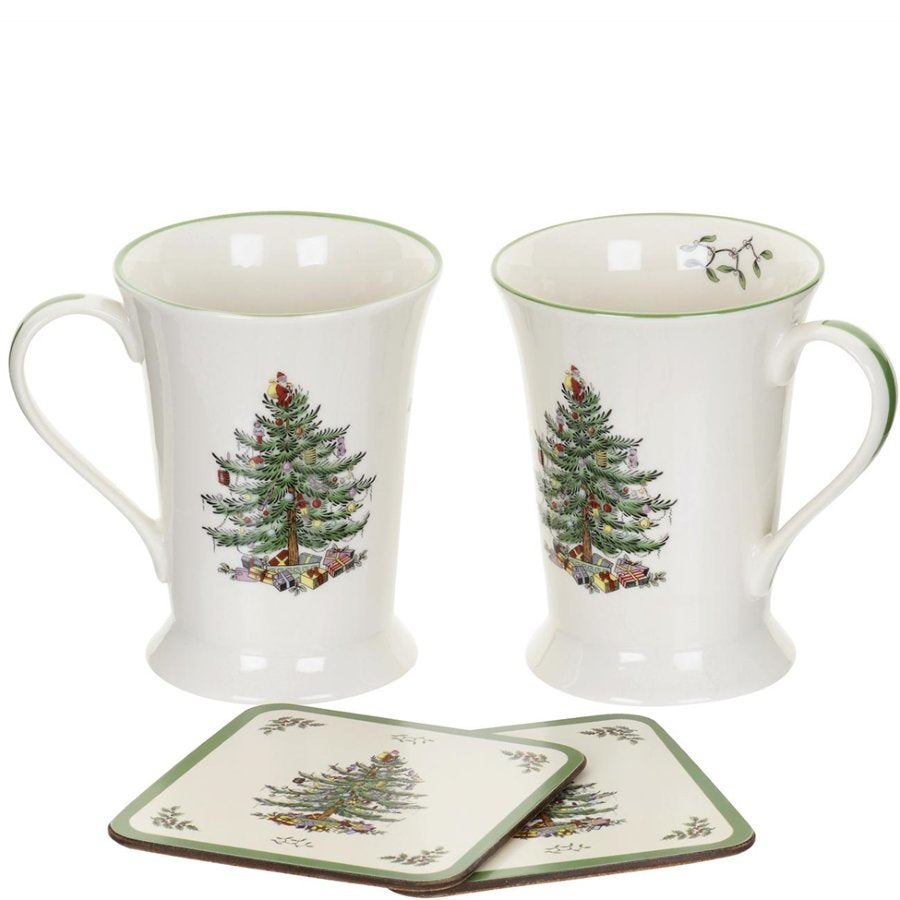 Two ceramic mugs with Christmas tree design and two matching coasters on a white background