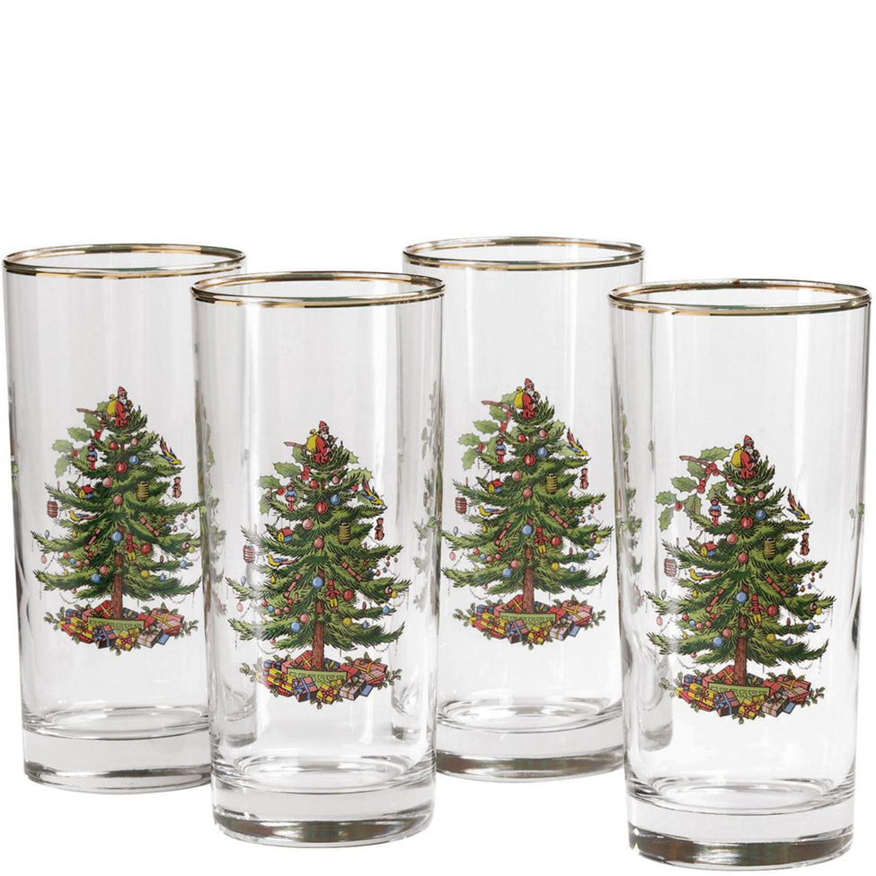 Set of four clear glasses with Christmas tree designs on a white background