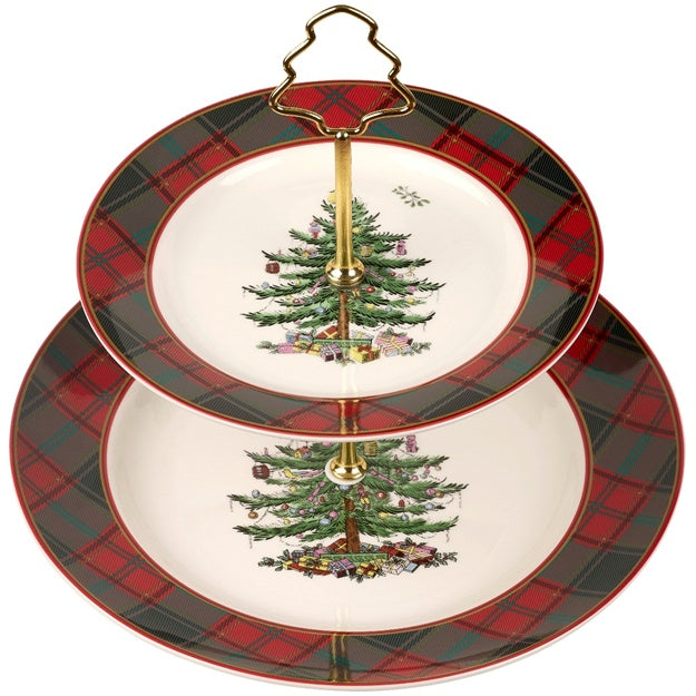 Two-tiered ceramic cake stand with Christmas tree design and plaid border on a white background