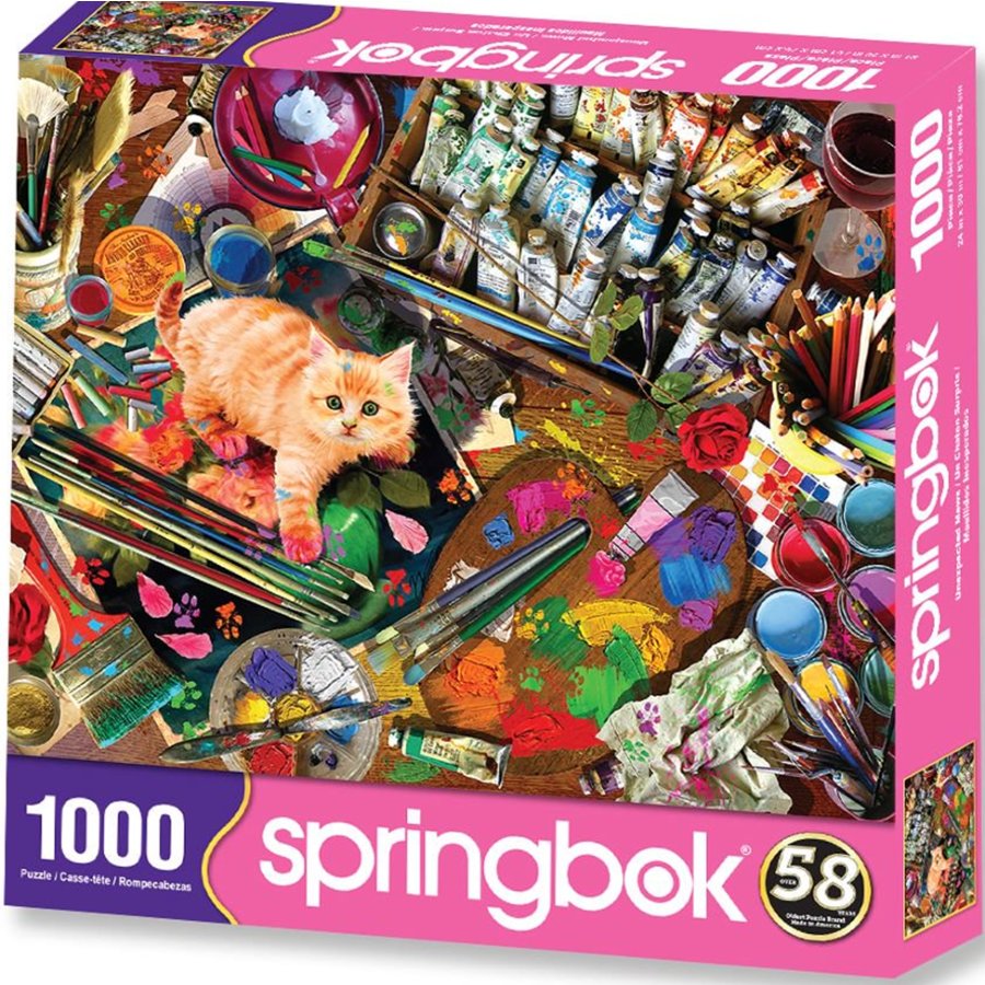 Springbok puzzle box with a cat and art supplies on a table