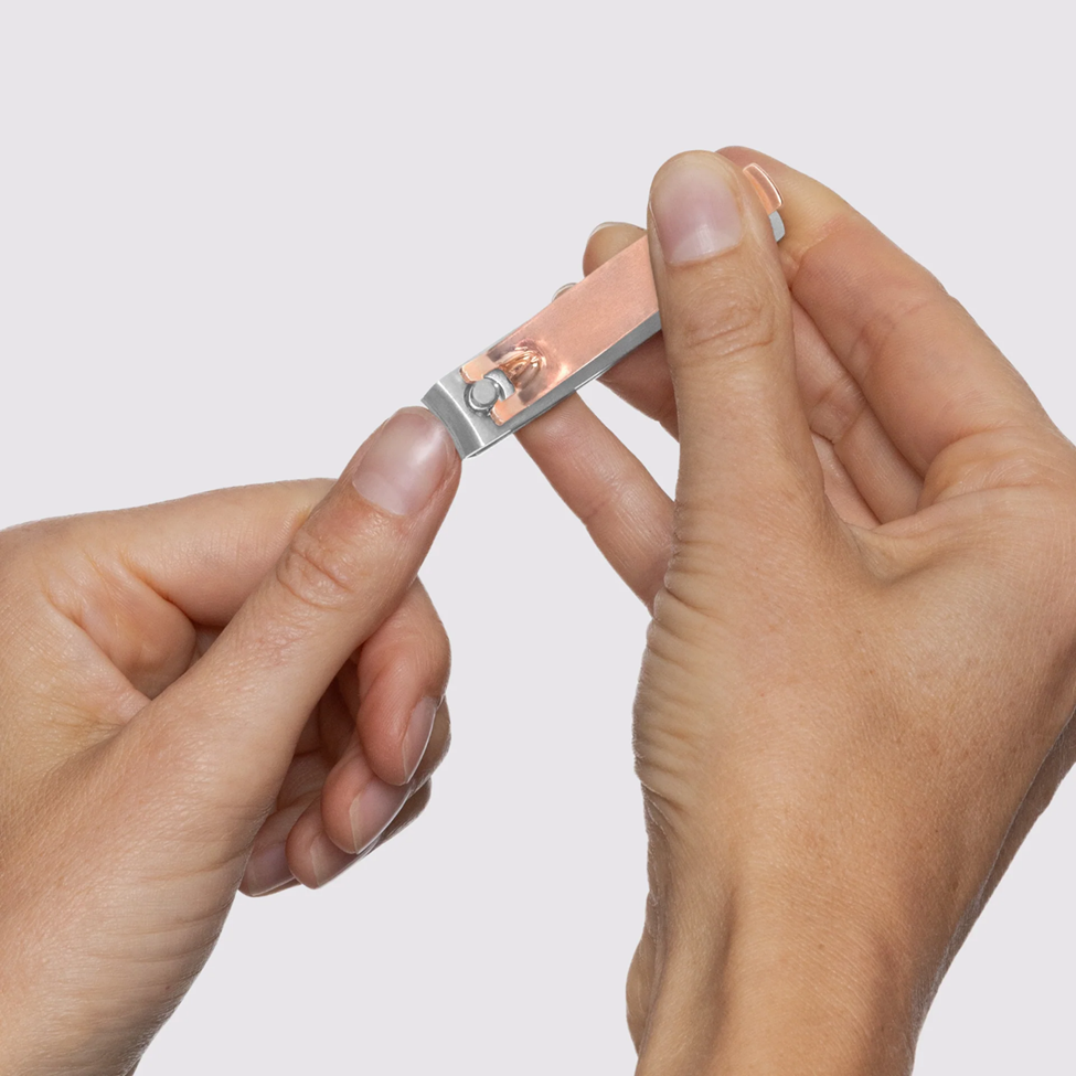 Close-up of hands holding a small electronic device against a light gray background