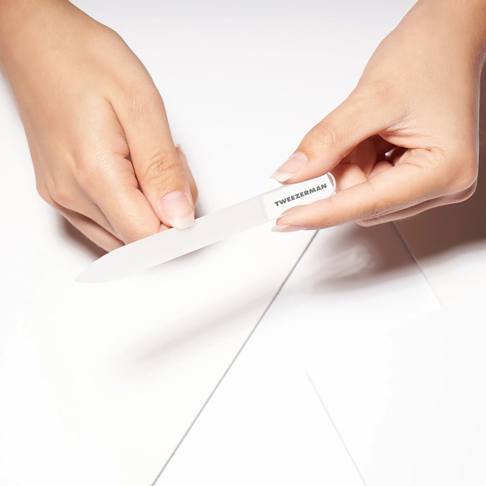 Person using a strip of tweezerman product on a white background