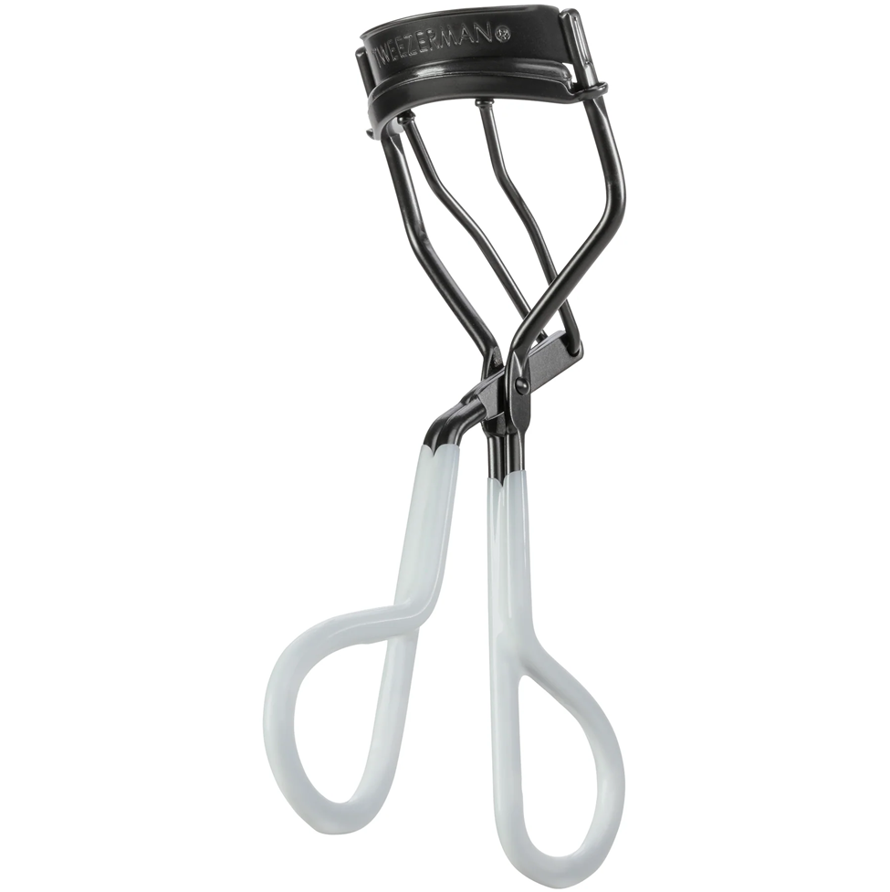 Eyelash curler with white handles and black metal frame on a white background