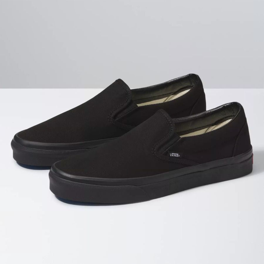 Pair of black slip-on shoes on a white background