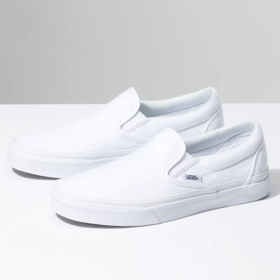 White slip-on sneakers on a light gray background