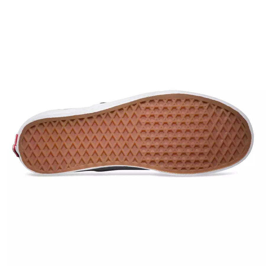 Close-up of a shoe sole with brown rubber and white tread pattern on a white background