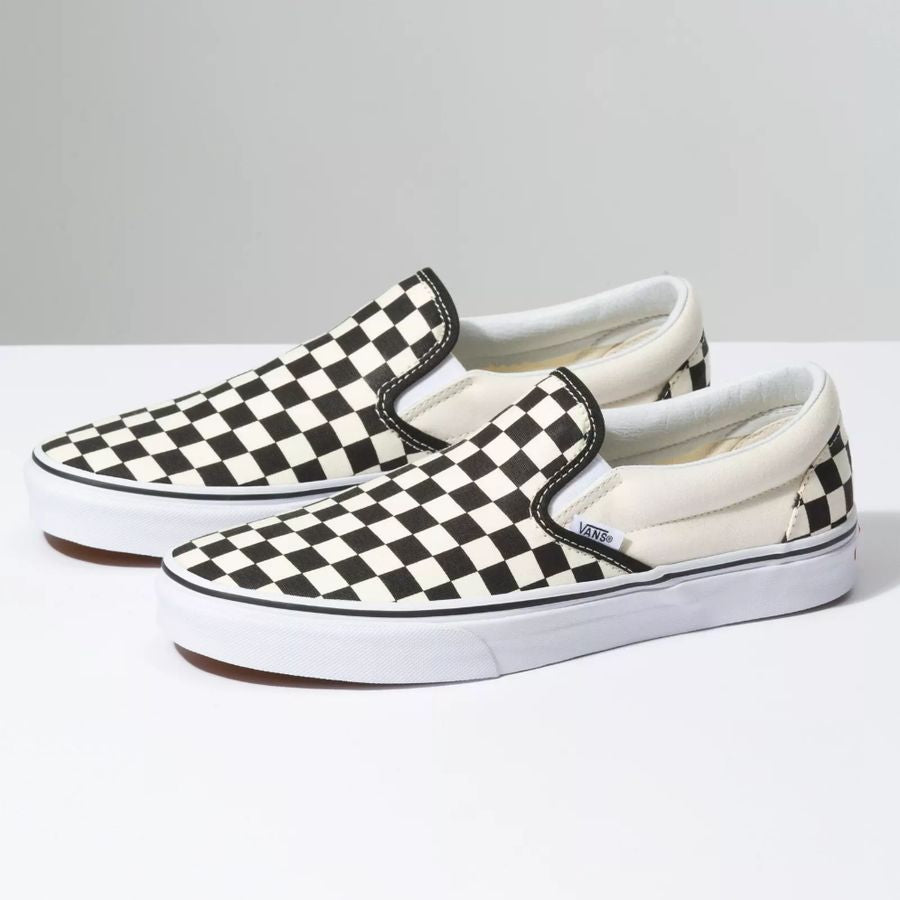 Pair of checkered slip-on shoes on a light gray background