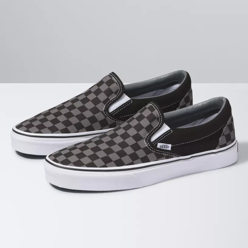 Pair of checkered slip-on shoes with white soles on a light gray background
