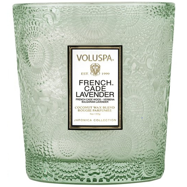 Green embossed candle with Voluspa label on a white background