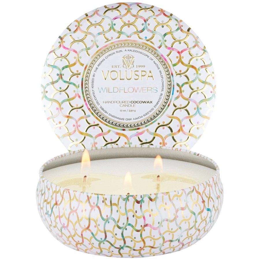 Decorative candle in a tin with 'Voluspa' branding on a white background