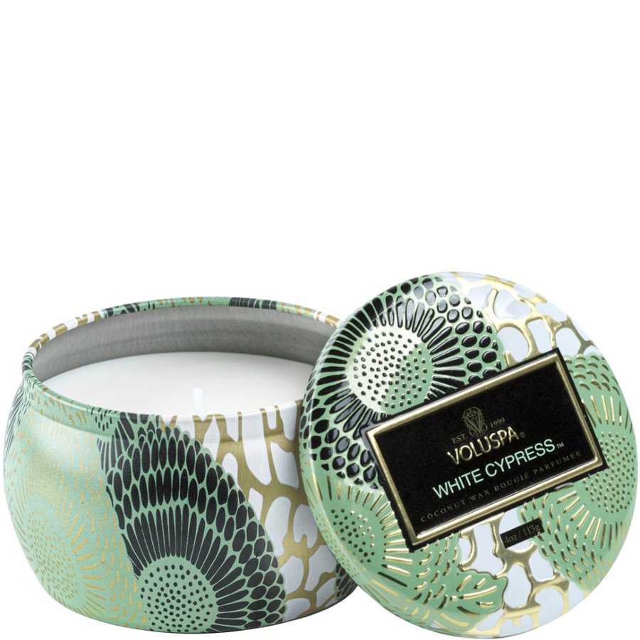 Decorative candle in a tin with a patterned lid on a white background