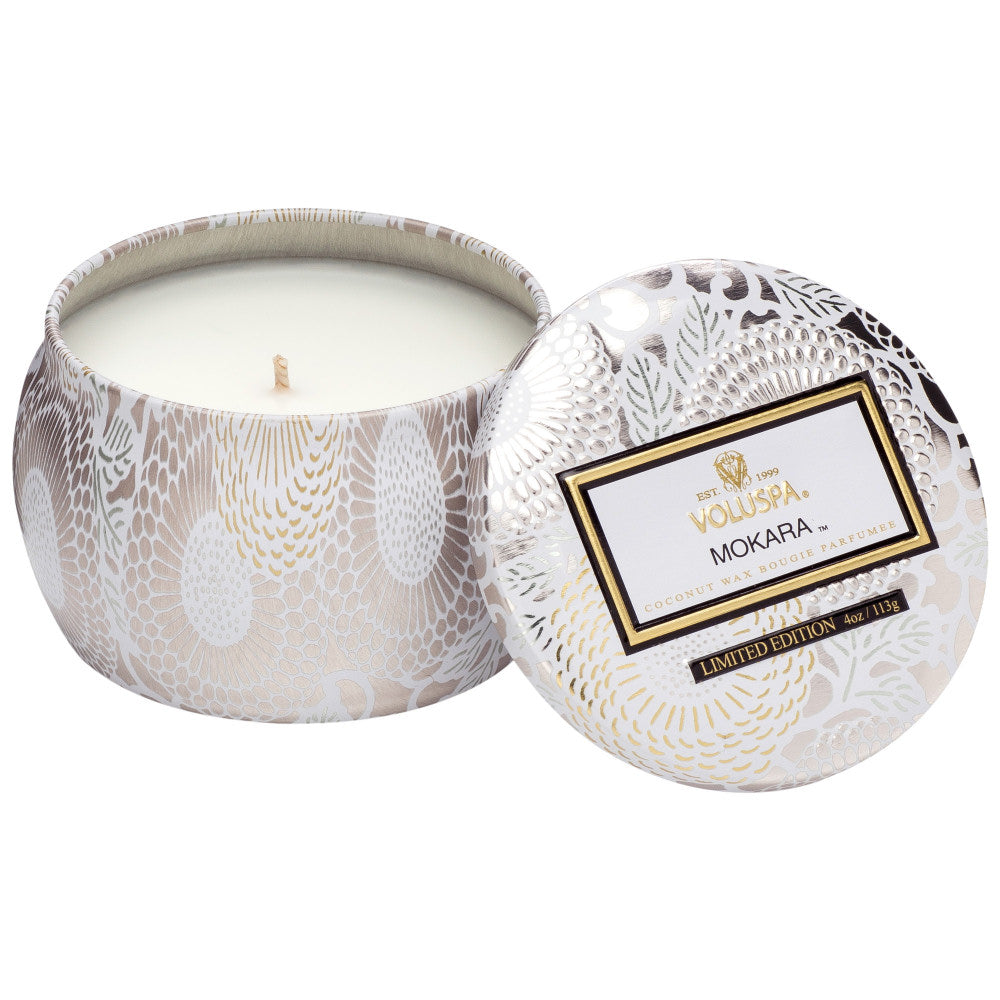 Candle in a decorative tin with 'Mokara' branding on a white background